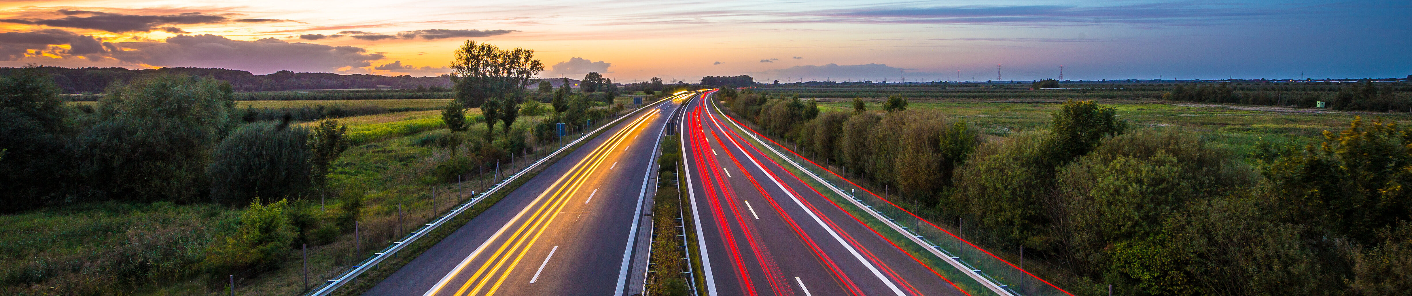 Highway at dusk with streaks of light from headlights 