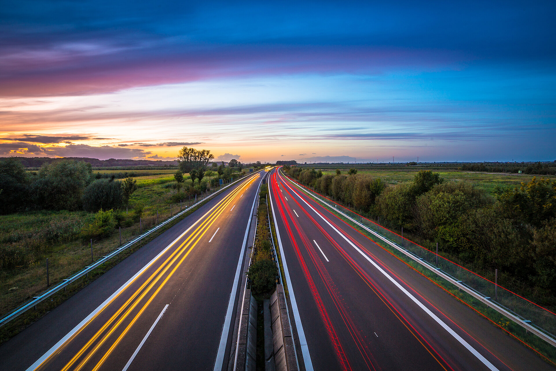 Highway at dusk with streaks of light from headlights 