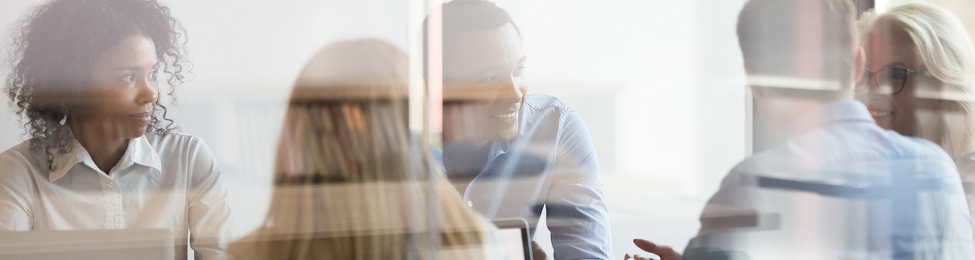 Multicultural employees talking at team meeting sit at conference table Multicultural employees talking at team meeting sit at conference table
