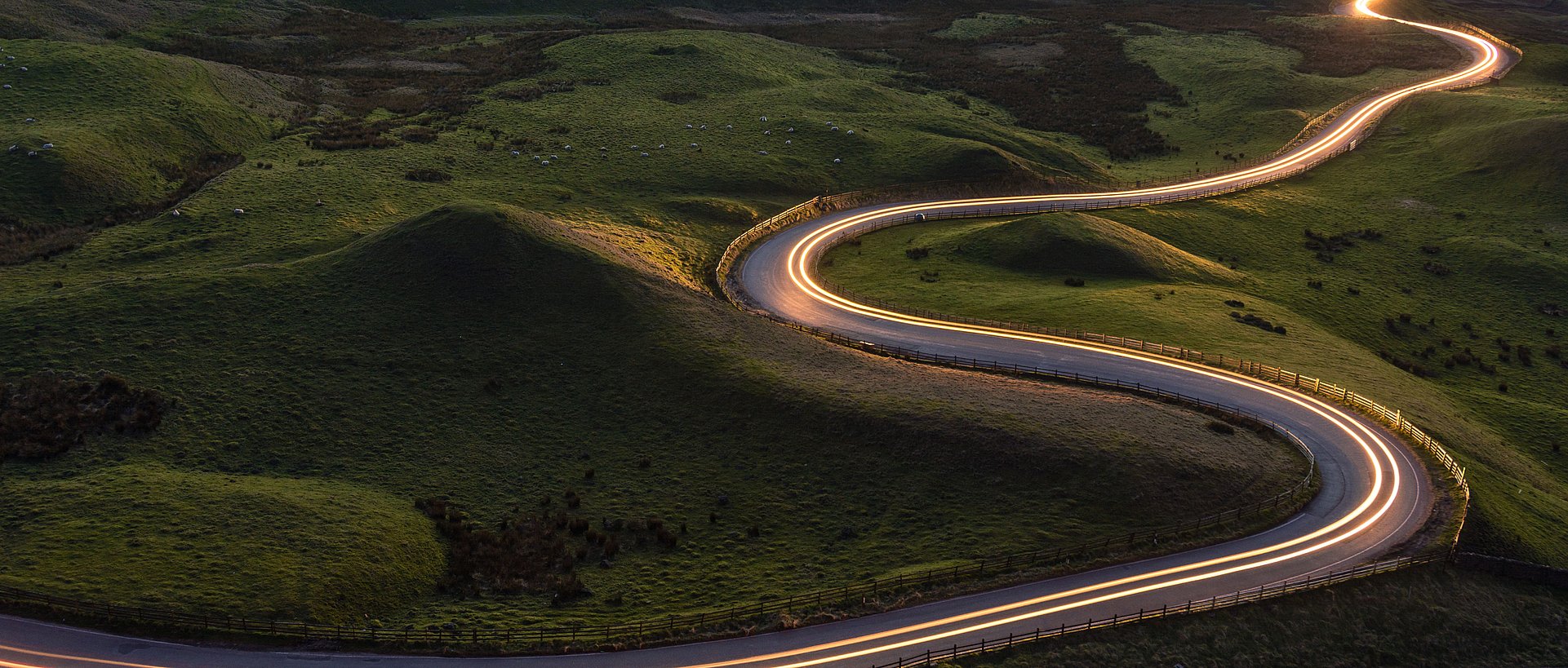 Winding curvy rural road with light trail from headlights leading through British countryside. Winding curvy rural road with light trail from headlights leading through British countryside.