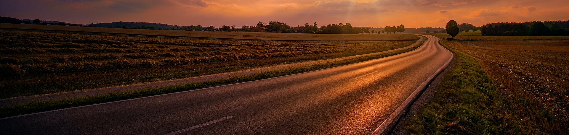Sunset setting over a road in the countryside Sunset setting over a road in the countryside