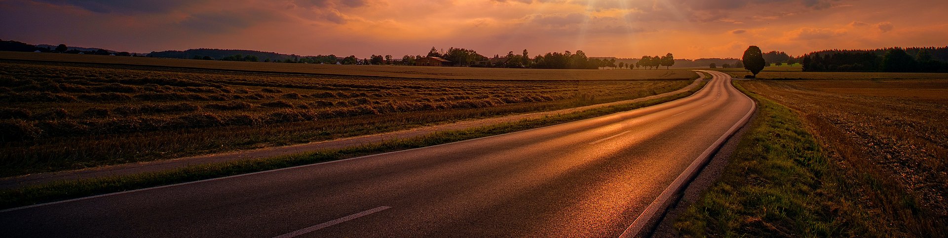 Sunset setting over a road in the countryside Sunset setting over a road in the countryside