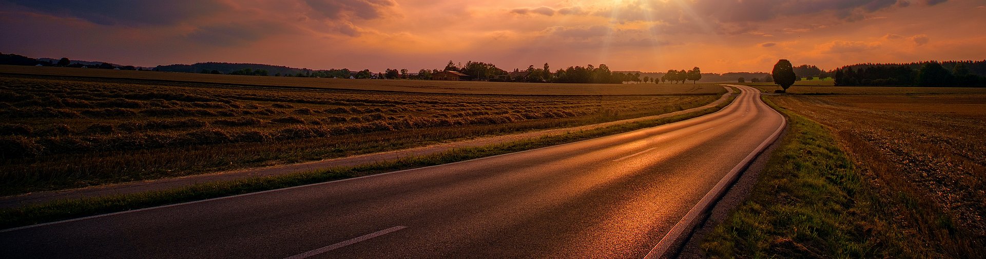 Sunset setting over a road in the countryside Sunset setting over a road in the countryside