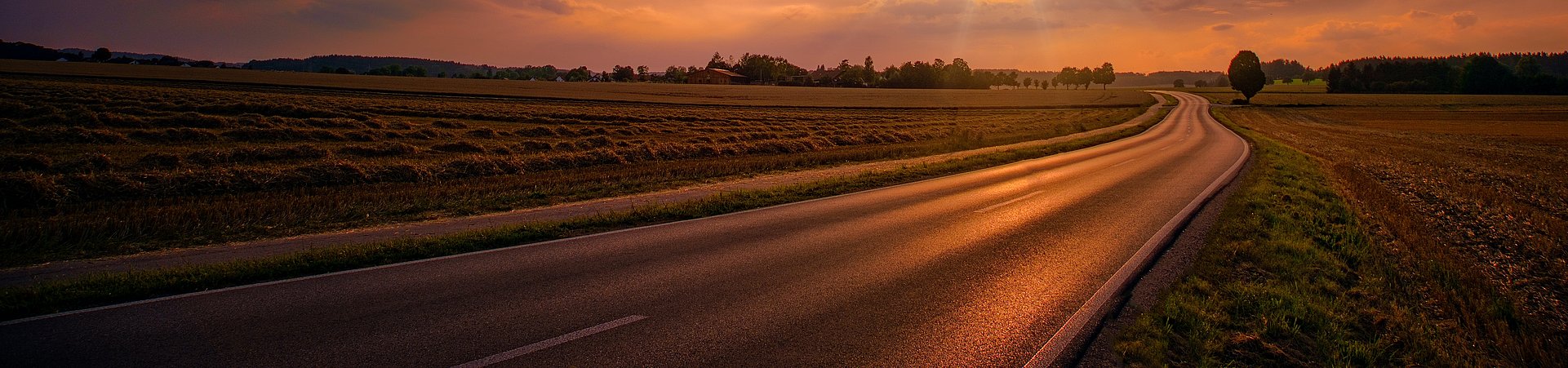 Sunset setting over a road in the countryside Sunset setting over a road in the countryside